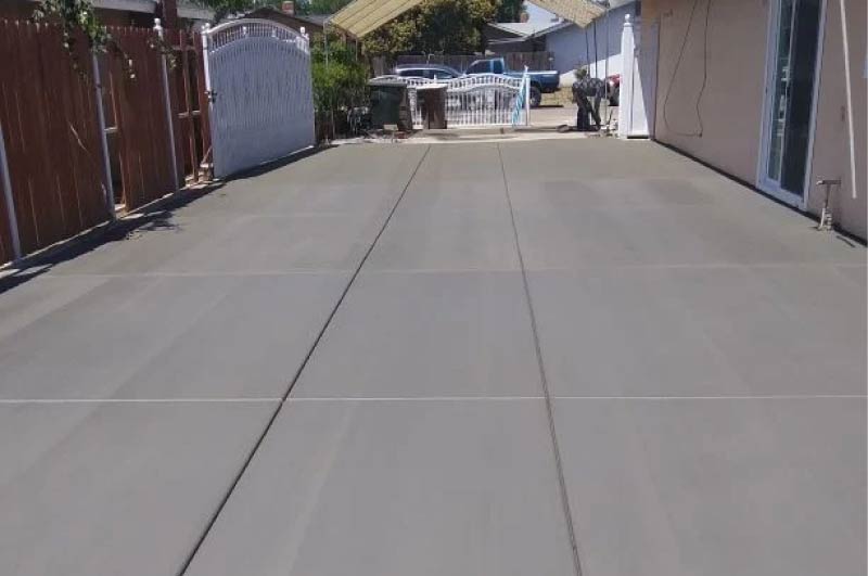 Finished concrete driveway slab with expansion joints in a residential backyard