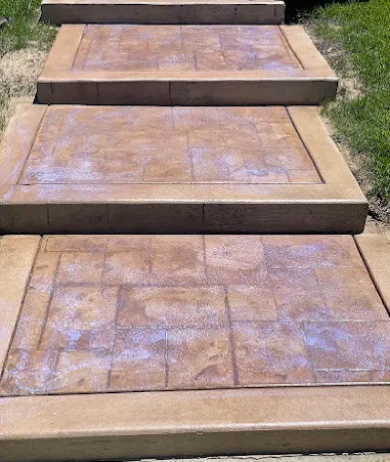Stamped concrete outdoor stairs with tile-pattern texture and border trim